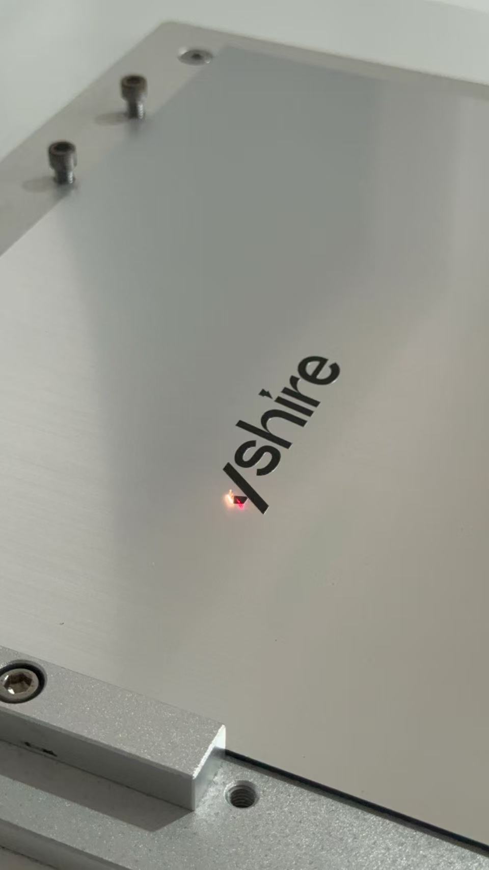 Laser engraving the LYSHIRE logo on an engraving sheet